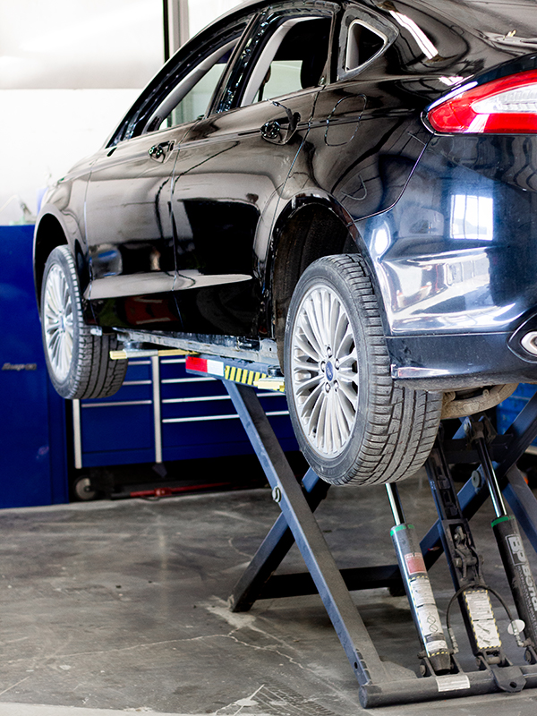 Black car on mechanical lift